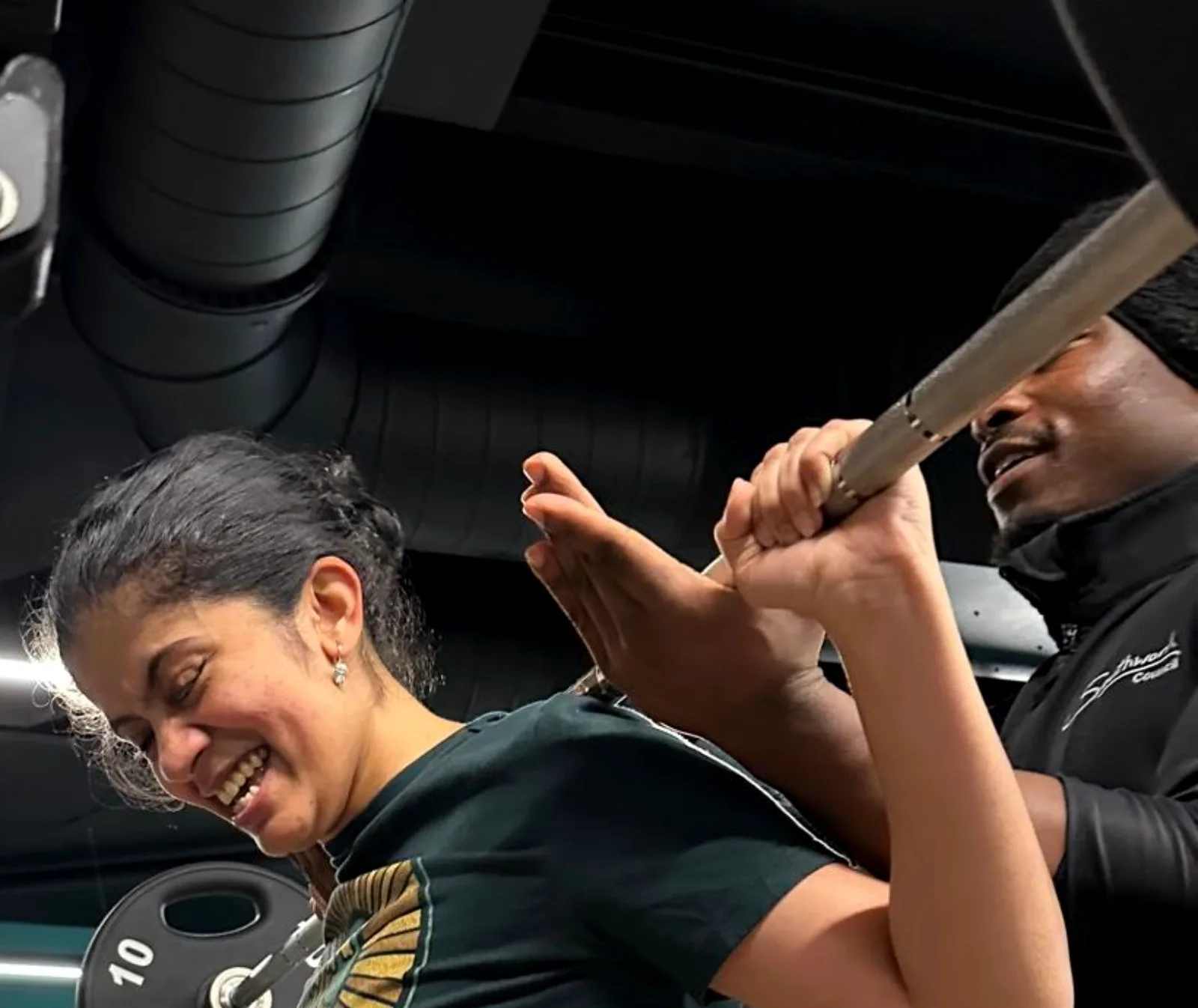 James coaching a client through a barbell squat