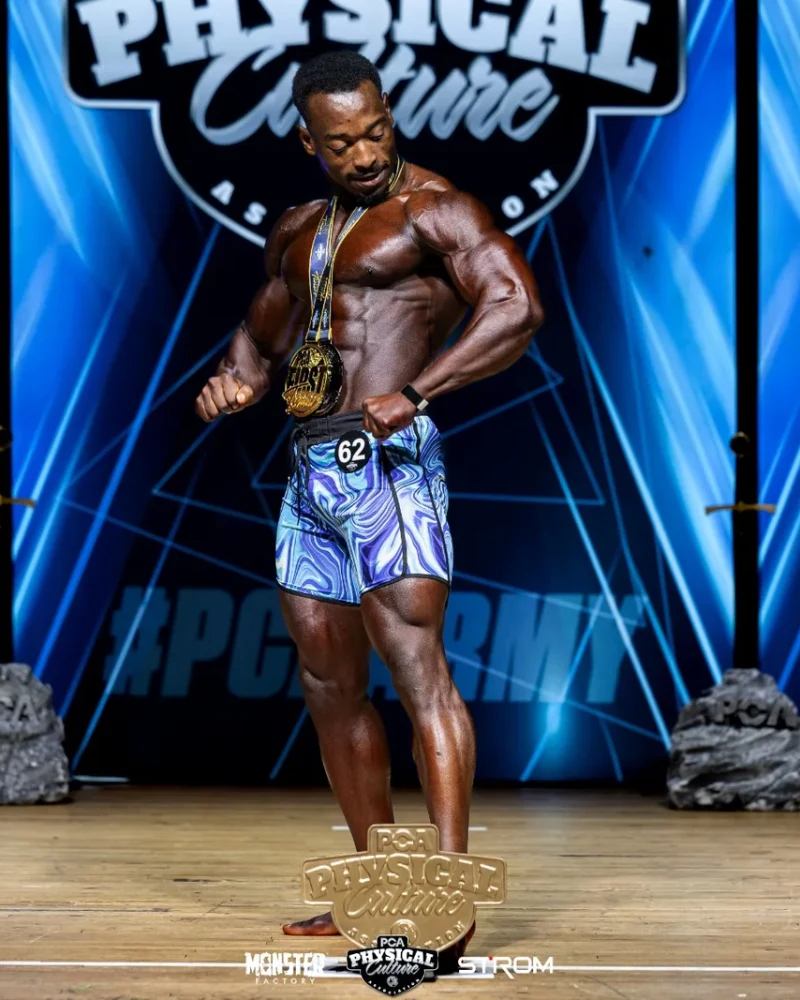 James posing on stage with his first place medal