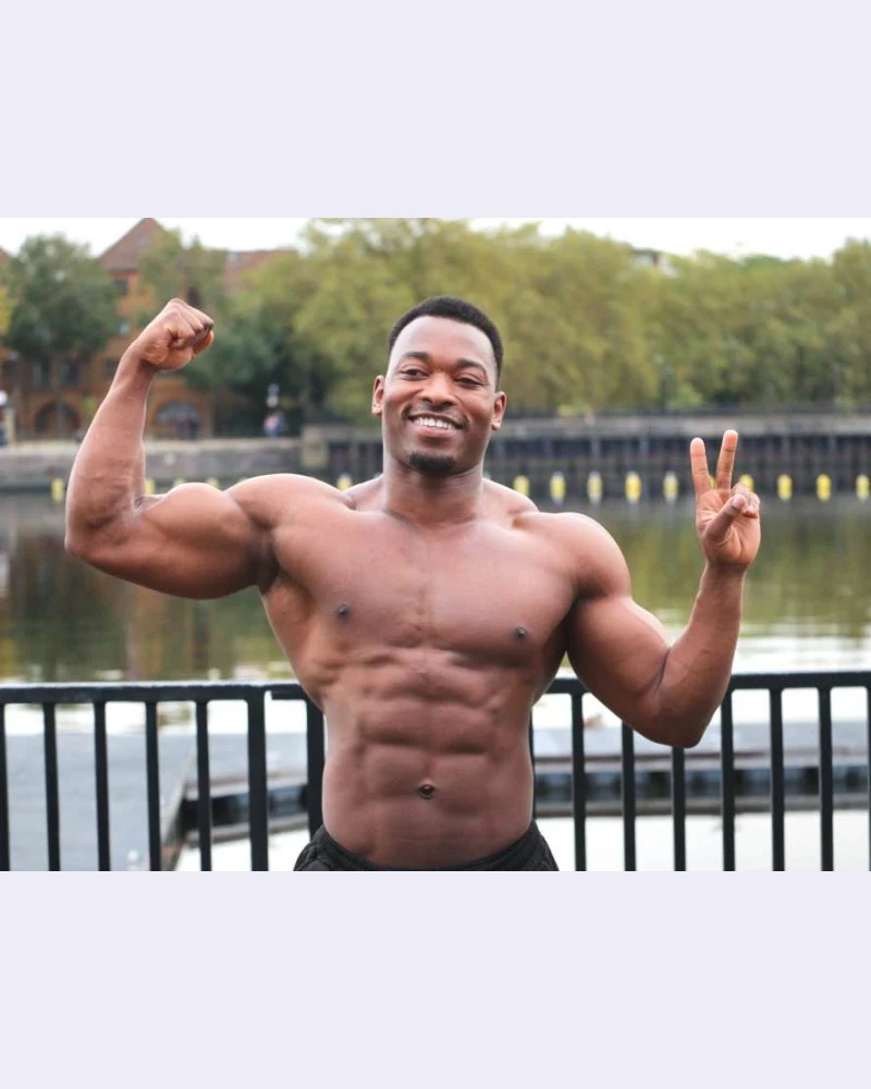 James flexing his bicep and giving a peace sign by the river